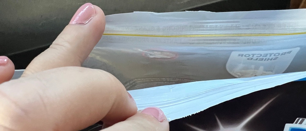 Eine Hand öffnet die Verpackung der Finish-Ultimate-Infinity-Shine-Spülmaschinentabs.