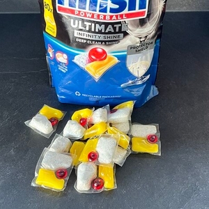 Einige Finish-Ultimate-Infinity-Shine-Spülmaschinentabs liegen vor ihrer Verpackung.