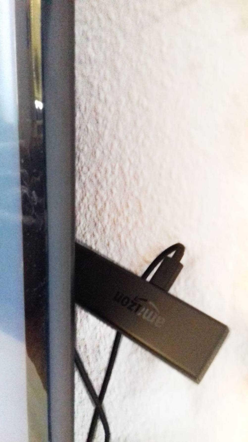 Fire TV Stick Test: Zwischen TV und Wand versteckt.