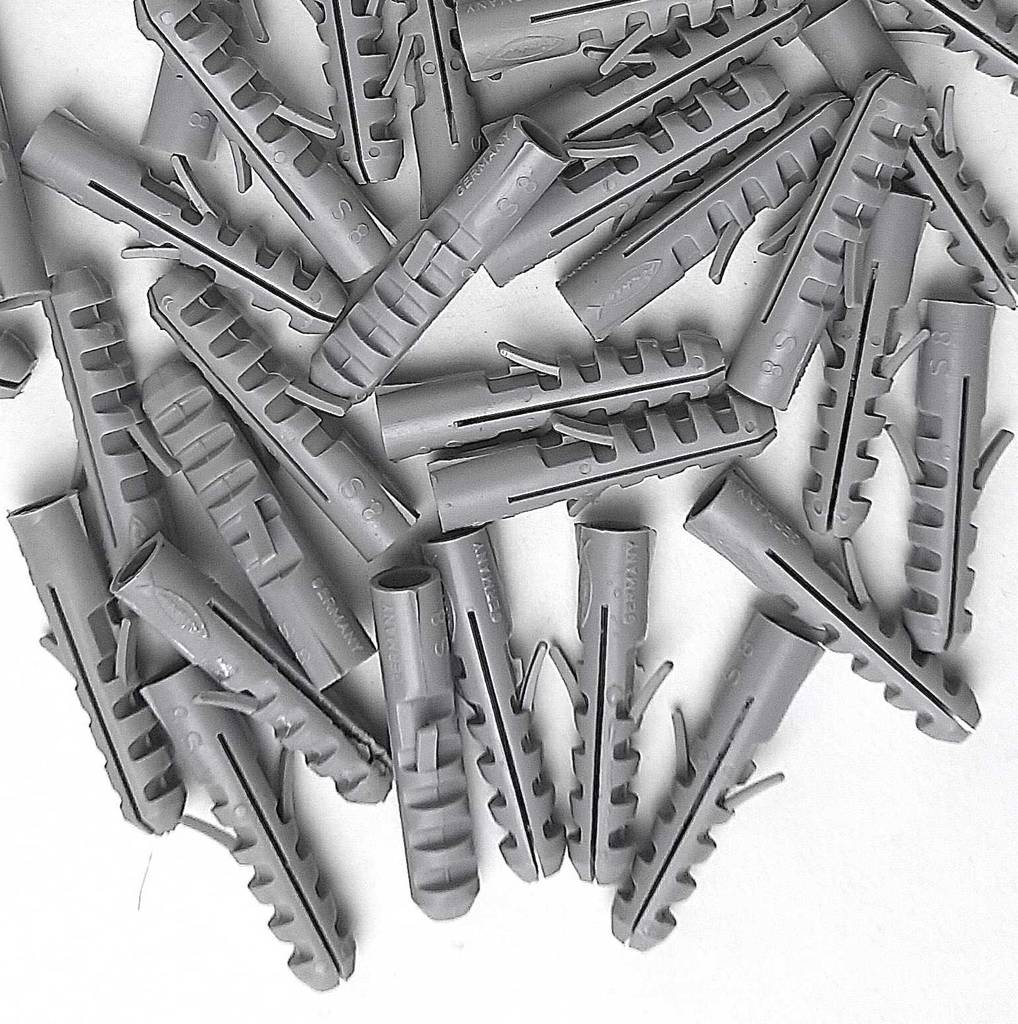 Nauhaufnahme vieler hellgrauer Dübel im Test.