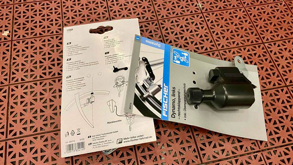Fahrraddynamo im Test: Verpackte Fahrraddynamos liegen auf gemusterten Untergrund.