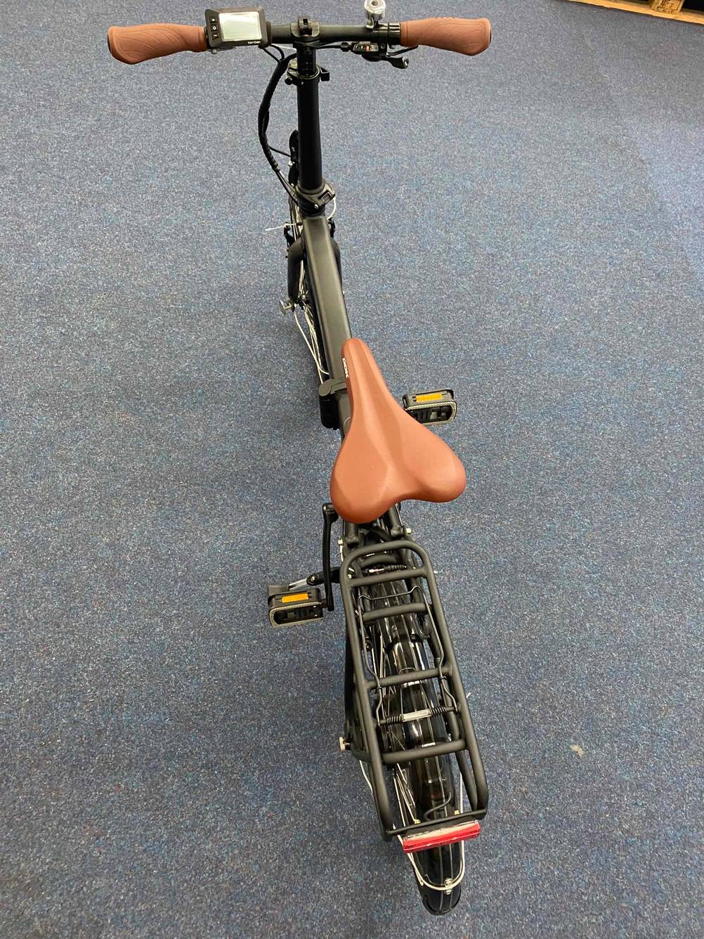 Ein E-Bike von hinten betrachtet steht getestet auf einem dunklen Boden.
