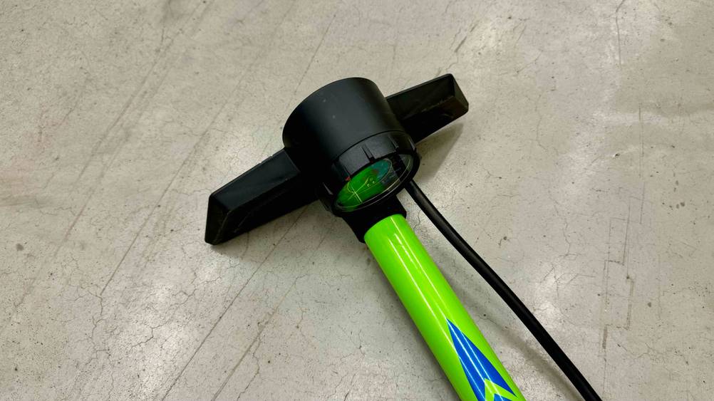 Im Test: Detailansicht des Standfußes einer auf dem Boden liegenden Standluftpumpe.
