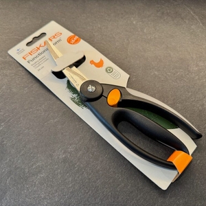 Die Fiskars 1003033 FF Geflügelschere liegt in ihrer Verpackung auf einer Küchenarbeitsplatte