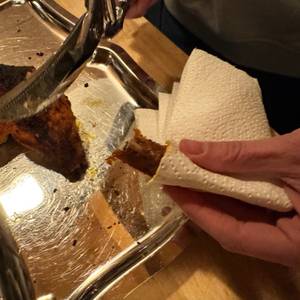 Eine Hand hält das Fleisch nach dem Schneiden mit der Fiskars 1003033 FF Geflügelschere fest