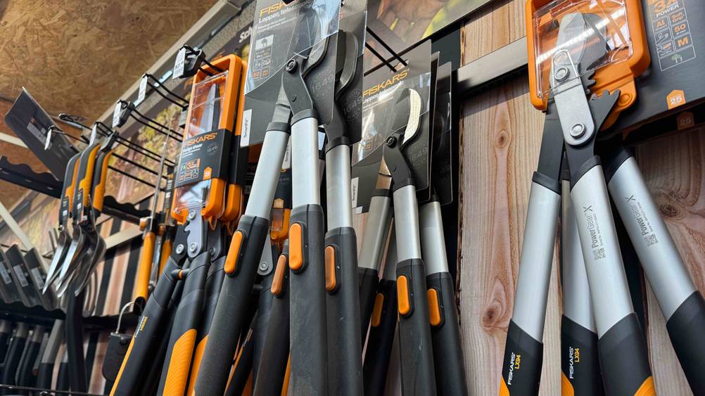 Mehrere getesteten Fiskars-Astscheren von schräg unten in einem Regal hängend.