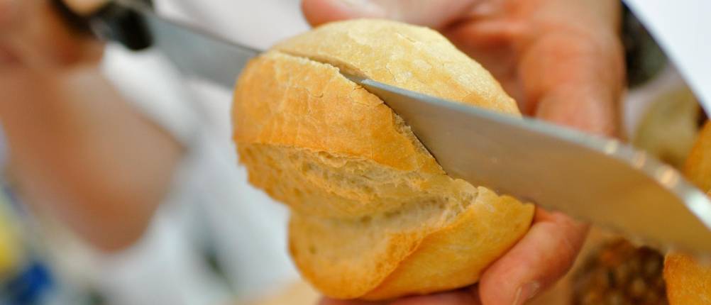 Fiskars-Brotmesser im Test: frisches Brötchen wird mit Brotmesser aufgeschnitten