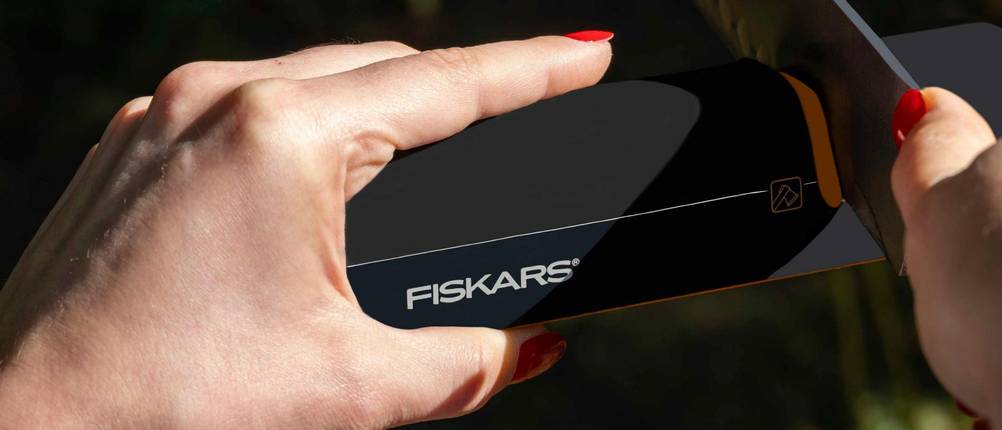 Fiskars-Brotmesser im Test: Messer wird durch Fiskars-Schleifgerät gezogen.