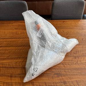 Die Messerwalze des Fiskars-Rasenlüfters ist in Luftpolsterfolie eingepackt.