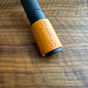 Ein oranger Ring zum Entriegeln des Griffs des Fiskars-Rasenlüfters.