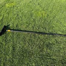 Der Fiskars-Rasenlüfter liegt auf einer Grasfläche.