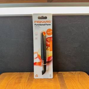 Der Fiskars Schäler stehend in seiner Verpackung.