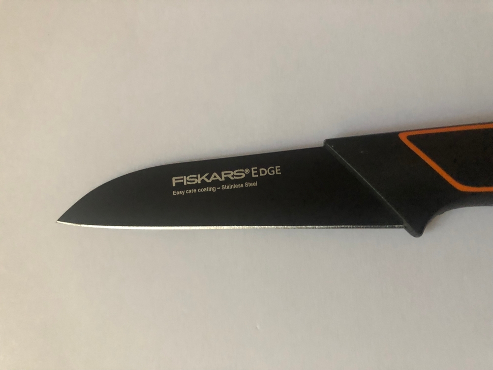 Fiskars-Gemüsemesser liegt auf weißer Oberfläche
