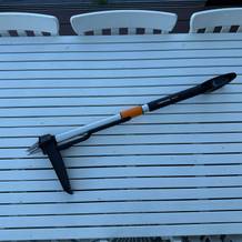 Der Fiskars-SmartFit-Teleskop-Unkrautstecher liegt auf einem Tisch.