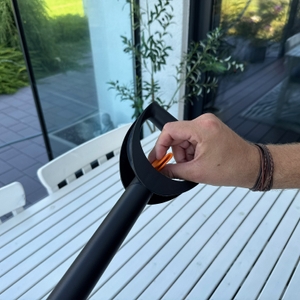 Eine Hand dreht an einem Drehregler des Fiskars-SmartFit-Teleskop-Unkrautstechers.