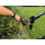 Eine Hand zieht ein Unkraut von der Spitze des Fiskars-SmartFit-Teleskop-Unkrautstecher