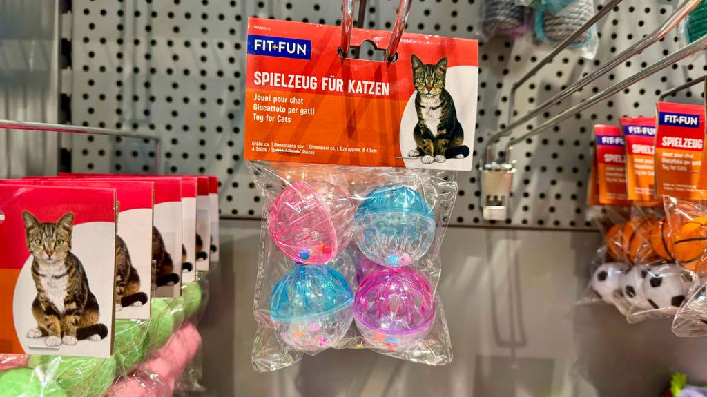 Im Test: Mehrere verschiedene Katzenspielzeuge hängen in einem Hängeregal.