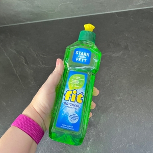 Das Fit-Spülmittel Original wird von einer Hand gehalten.