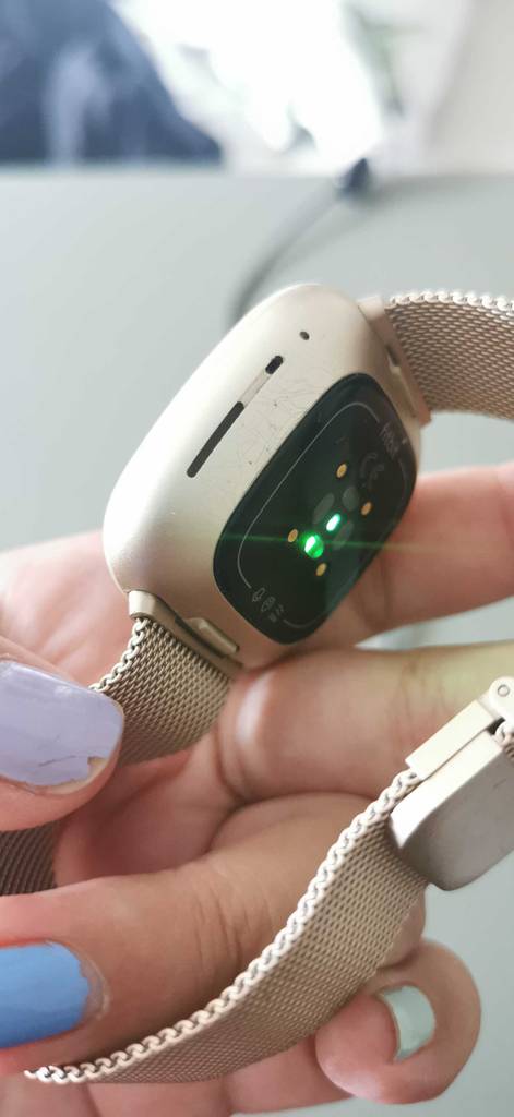 Hand hält eine getestete Fitbit und zeigt die Rückseite und das Band.