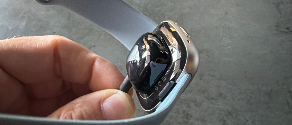 Das Ladekabel hängt an der Fitbit Versa 4