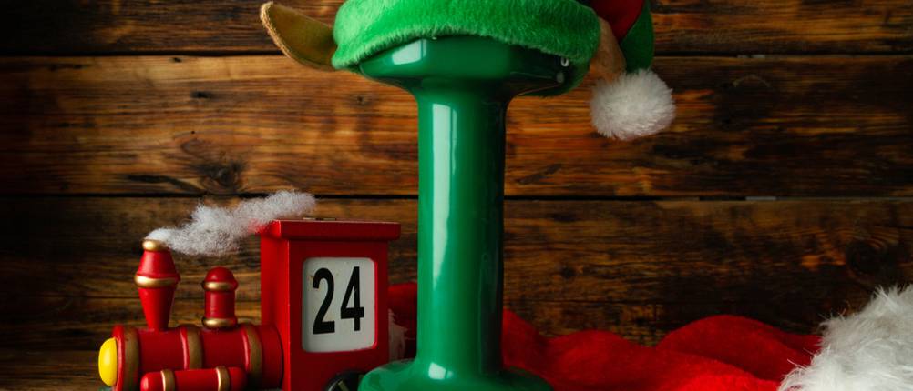 Fitness-Adventskalender im Test: Eine grüne Hantel mit Elfenmütze, weihnachtlicher Deko und einem Zug mit der Nummer 24 darauf. 