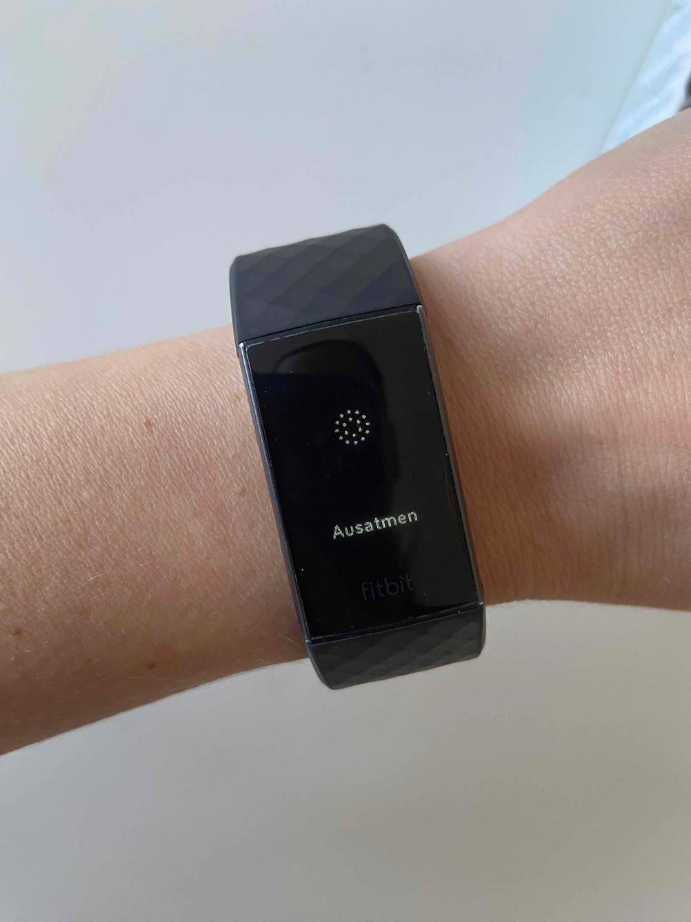 Im Test: An einem Handgelenk befindet sich ein Fitness-Armband mit einer Aufforderung zum Ausatmen.