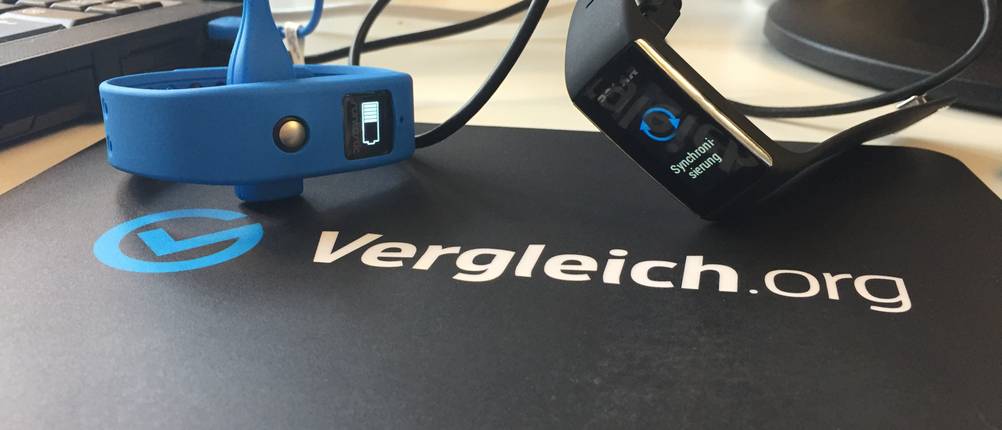 Fitness-Armband-Test: Fitness-Armbänder am Ladegerät auf einem Tisch