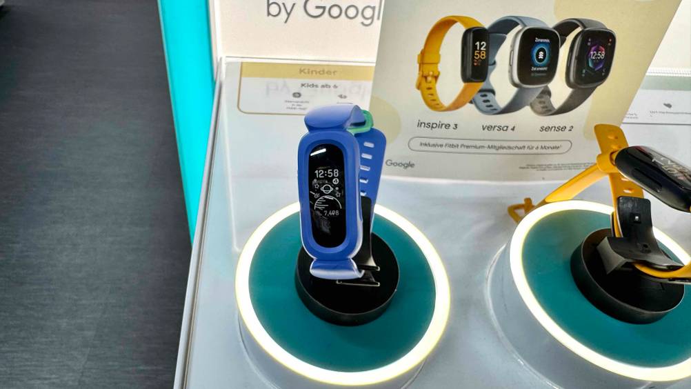 Getestet: Ein Fitness-Tracker für Kinder von vorne auf einem Ständer vor einem Plakat.