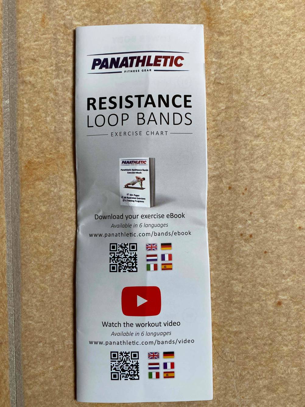 Im Test: Bedienungsanleitung für ein Fitnessband auf einer Holzfläche.