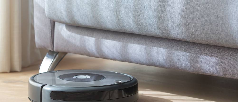 Staubsauger-Roboter-Test: Staubsauger-Roboter fährt unter ein Sofa.