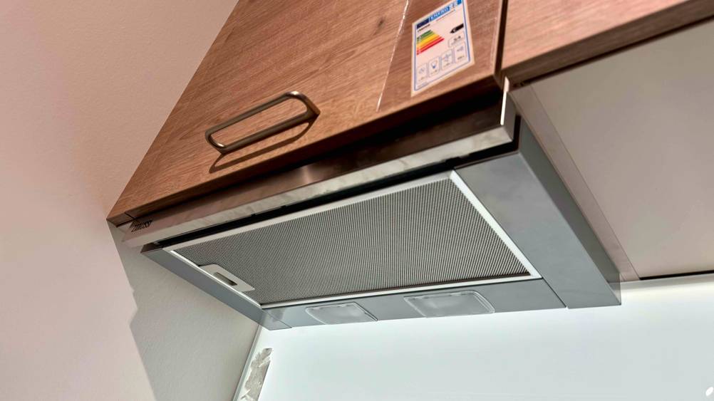 Flachschirmhaube getestet: Ein Gerät unter einem Küchenschrank montiert von schräg unten.