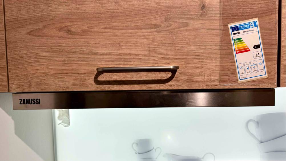 Getestet: Eine Flachschirmhaube eingefahren von vorne unter einem Schrank monitert mit Logo.