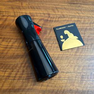 Der Flairosol-Olivia-Olivenöl-Sprüher liegt neben seiner Anleitung auf einem Tisch