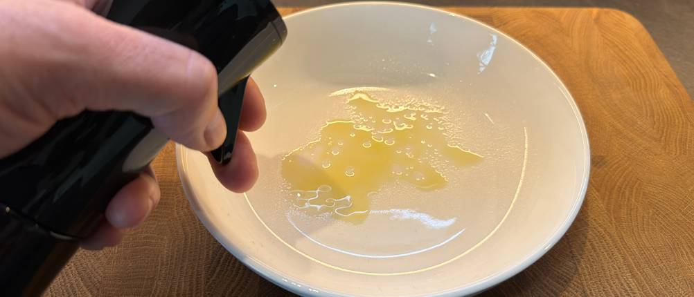 Mit dem Flairosol-Olivia-Olivenöl-Sprüher wird Öl in einen Suppenteller gesprüht