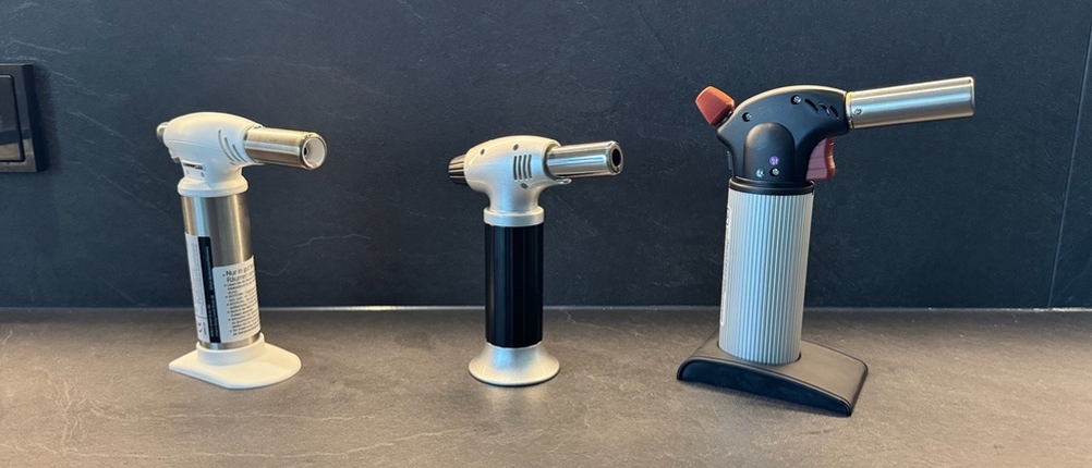 Drei Flambierbrenner stehen nebeneinander auf einer Arbeitsplatte