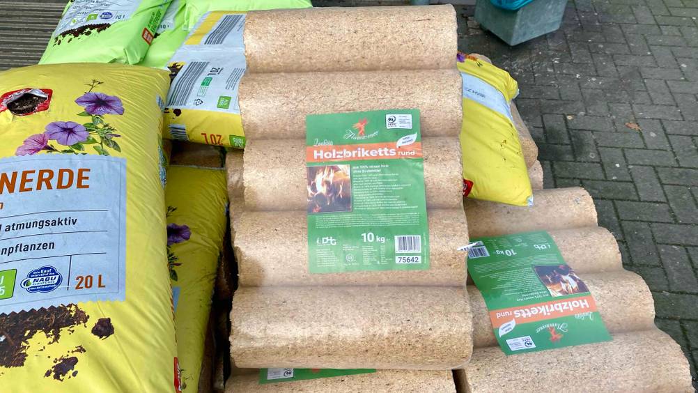 Neben den getesteten Holzbriketts liegen weitere Produkte.