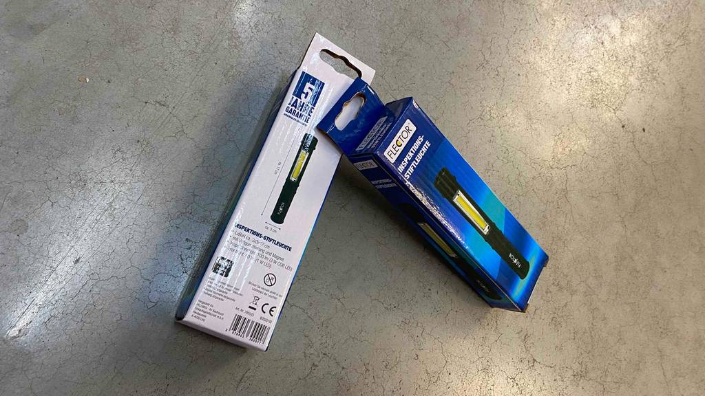 Stiftlampe im Test: zwei Verpackungen von Flector liegen angelehnt aneinander auf einem Boden.