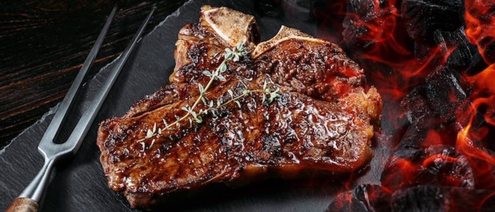 Fleischgabel am Grill getestet: Ein Grillkotelett in Nahaufnahme mit einer Fleischgabel daneben.