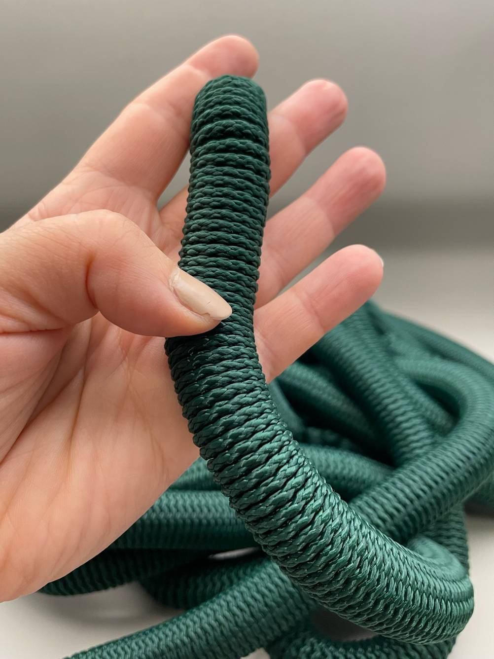 Flexibler Gartenschlauch (15m) im Test: Nahaufnahme der Strucktur des Schlauches von einer Hand gehalten.l