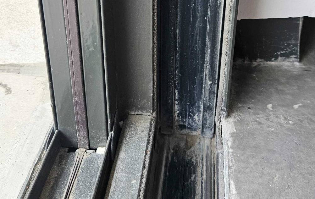 Nahaufnahme der vor der Glastür im Innenraum eingelassenen Profilschiene einer getesteten Fliegengitter-Schiebetür.