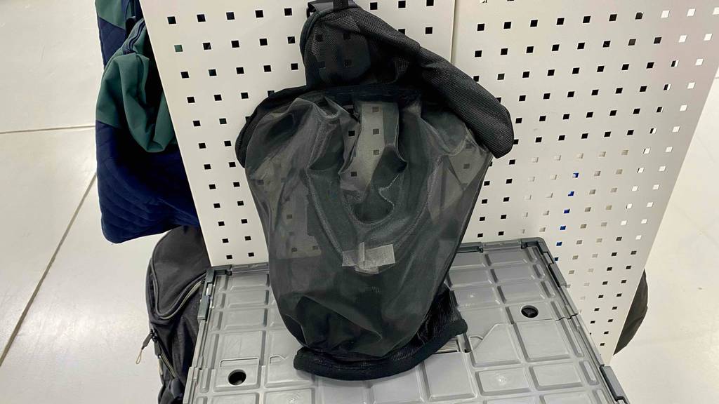 Eine getestete Fliegenmaske für Pferde aus atmungsaktivem Material befindet sich auf einer Kiste. 