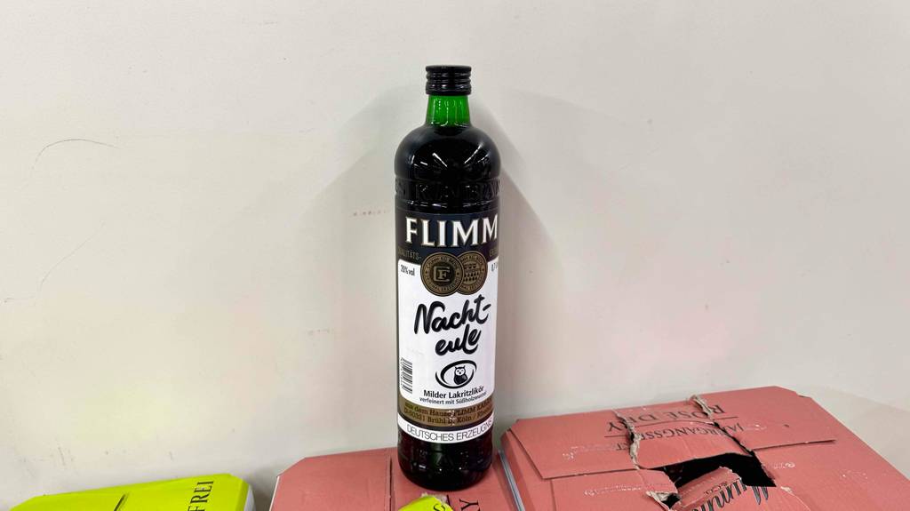 Eine Flasche mit getestetem Lakritzlikör steht auf einem Weinkarton.