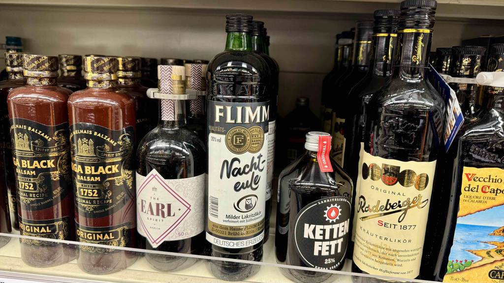 Im Test: Lakritzlikör in der Flasche steht neben weiteren Likören in einem Verkaufsregal im Supermarkt.