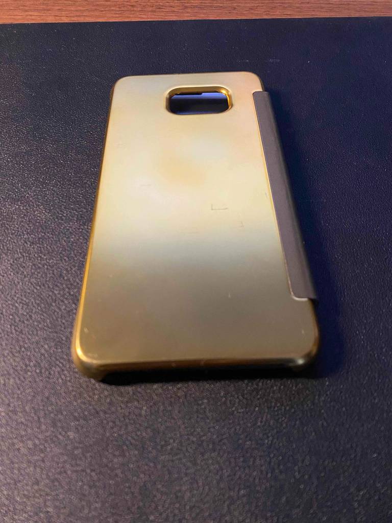 Ansicht von hinten auf eine goldene, getestete Samsung-Galaxy-S8-Hülle, mit Fokus auf den Schutzrand der Kameraaussparung, auf schwarzem Untergrund.