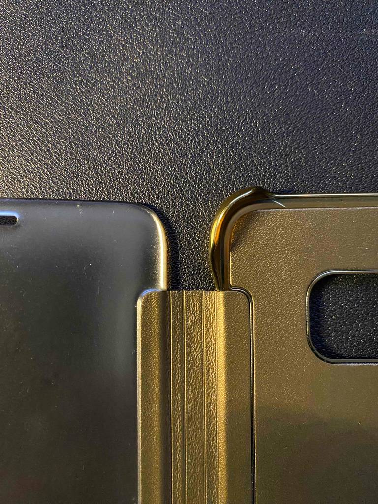 Detailansicht des Eckschutzes einer goldenen, getesteten Samsung-Galaxy-S8-Hülle vor schwarzem Hintergrund.