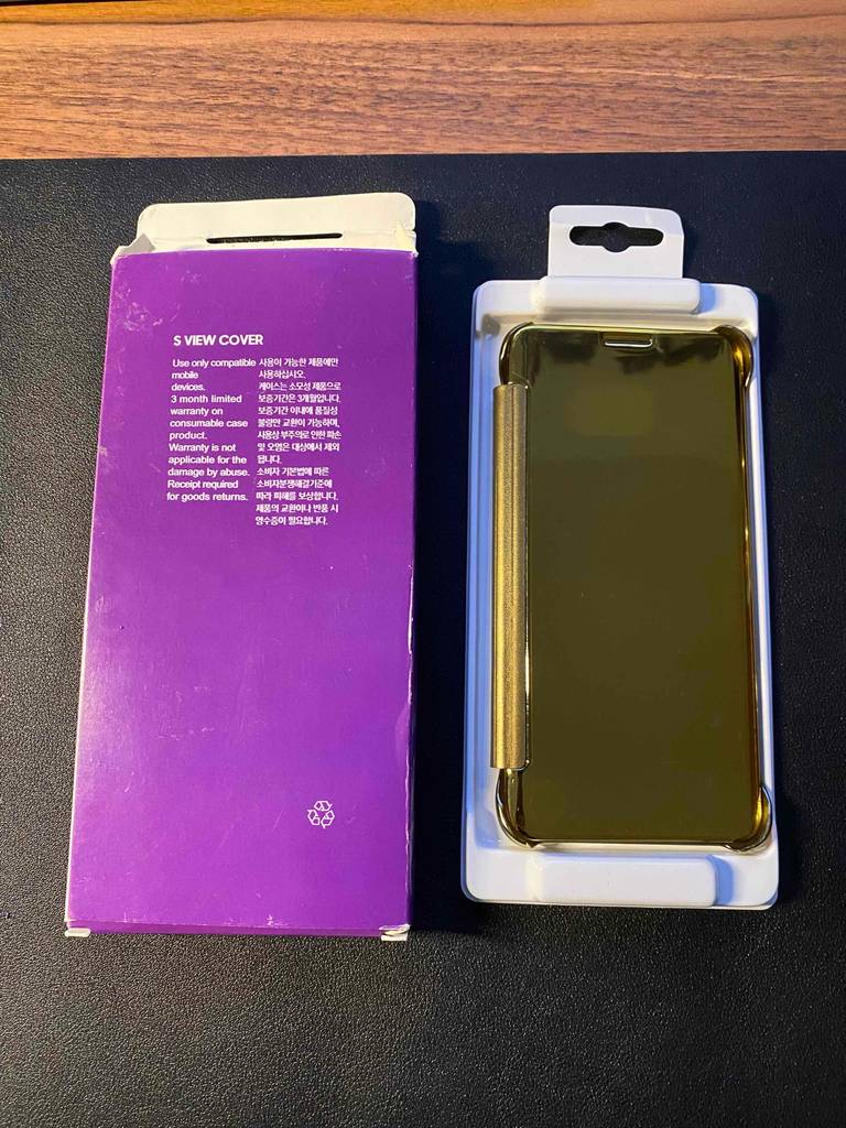 Eine goldene Samsung-Galaxy-S8-Hülle im Test befindet sich neben ihrer violettfarbenen Verpackung auf einem schwarzen Untergrund.