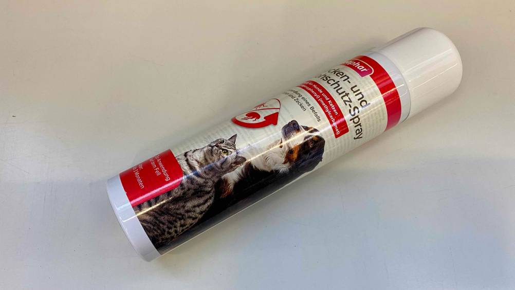 Eine Dose des getesteten Flohsprays schräg auf einer hellen Fläche liegend.