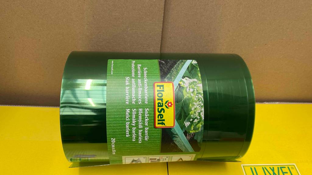 Schneckenzaun im Test: Eine Verpackung mit eingerolltem Schneckenzaun in acht Meter Länge und zwanzig Zentimeter Höhe liegt auf einem gelben Karton.