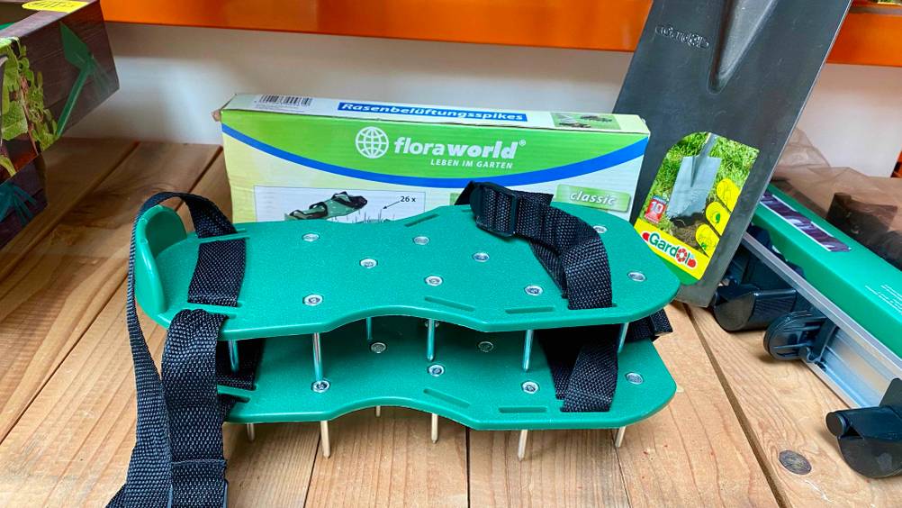 Rasenlüfter-Schuhe-Test: Zwei Schuhe übereinander gestapelt auf einem Holzregal.