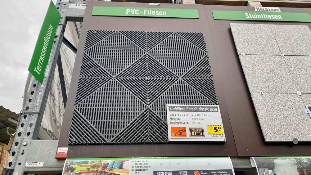Vier getestete Terrassenplatten verlegt auf einem Ausstellungsdisplay mit Preisangabe.